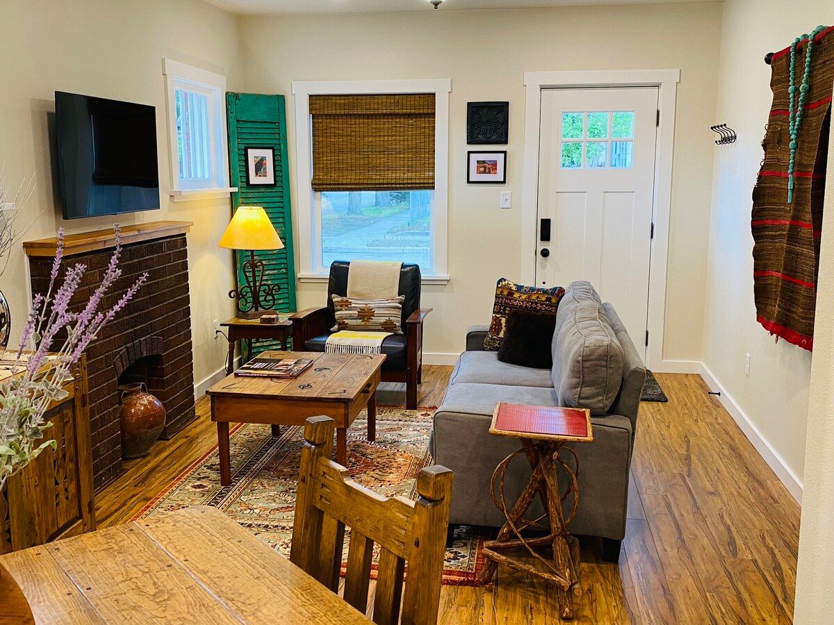 Living room with fireplace, sofa and woven textile on the wall