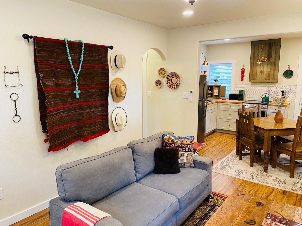 Sofa under a woven wall hanging with a view to the kitchen