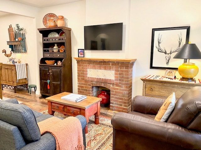 Living room with brick fireplace, leather sofa and framed art