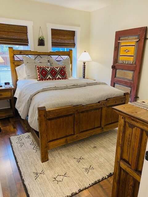 Bedroom with rustic wood bed and a distressed red door