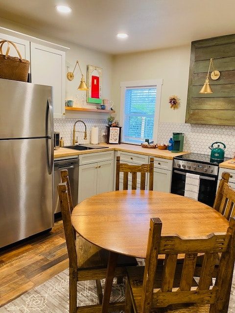Kitchen with round wood table and stainless refrigerator