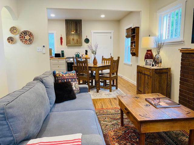 Living room with gray sofa, wooden coffee table and dining area beyond