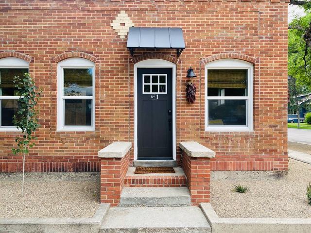 Casita front door with arched brick surround and tidy gravel entry