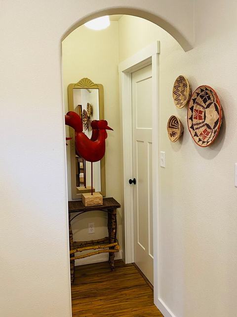 Arched hallway with decorative baskets and a red rooster figure