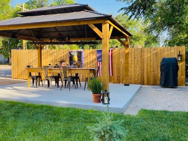 Covered patio gazebo with dining table and grill