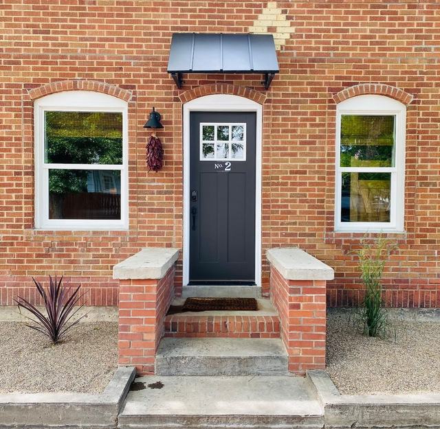 Casita front door with arched brick surround and stone steps