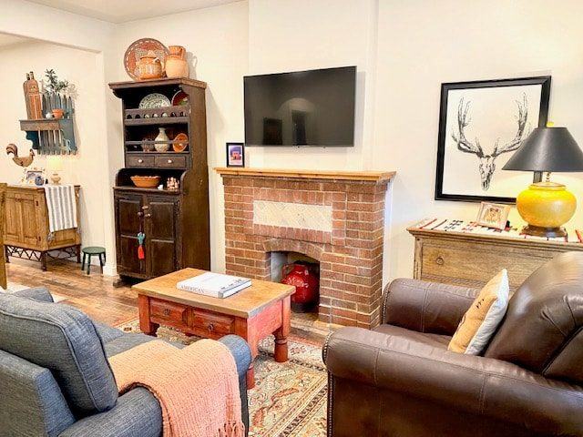 Living room with brick fireplace, leather sofa and framed art
