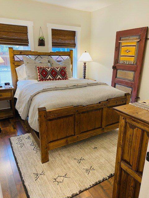 Bedroom with rustic wood bed and a distressed red door